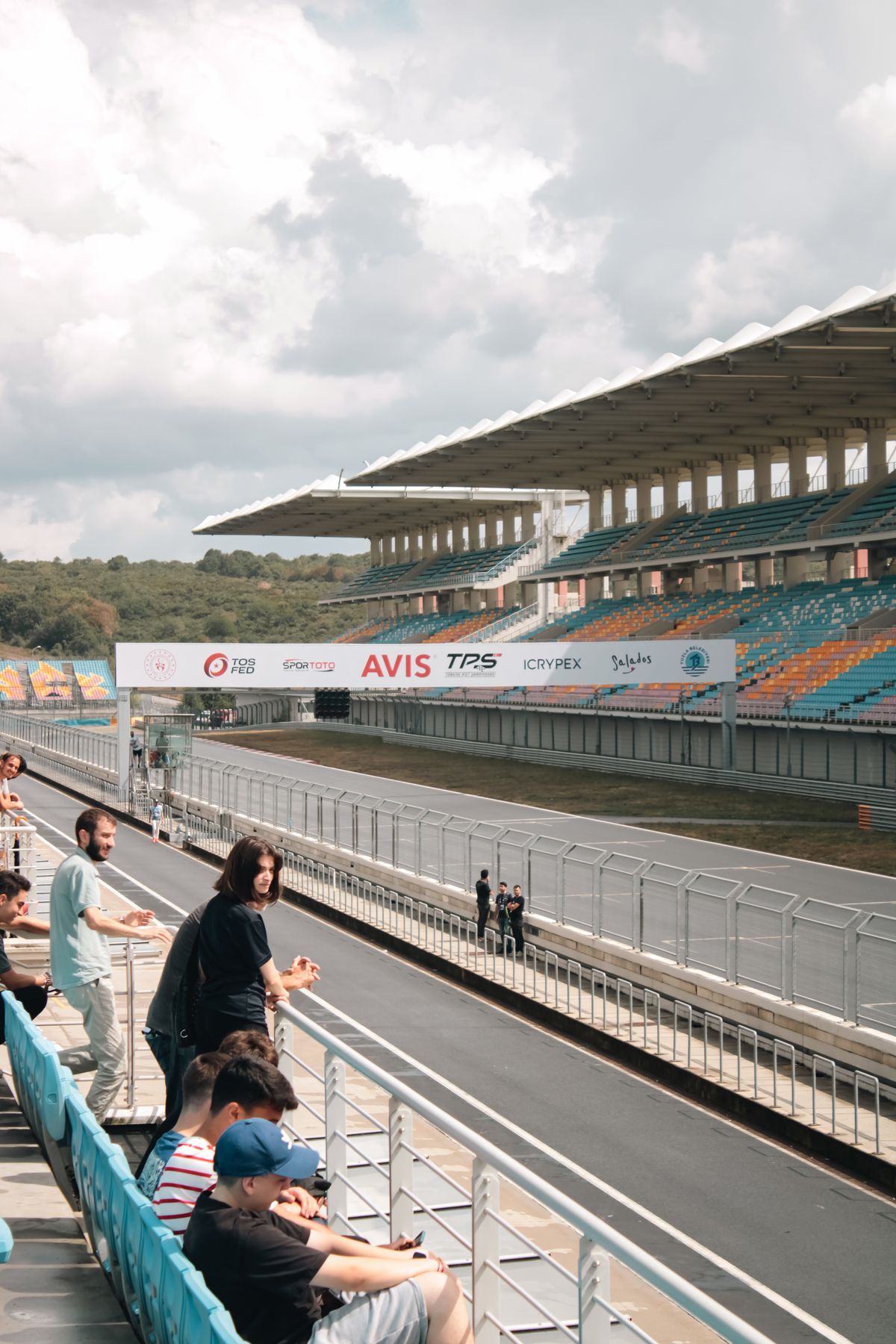 A vibrant view of a race track with spectators watching the event from bleachers.